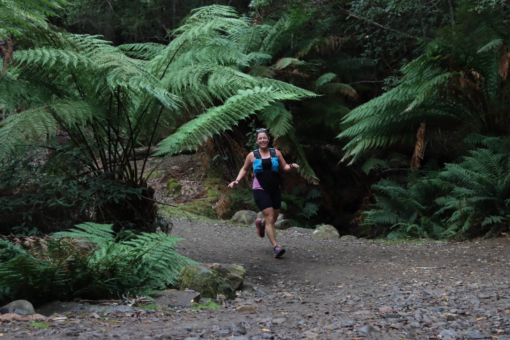 Woman running amongst ferns 